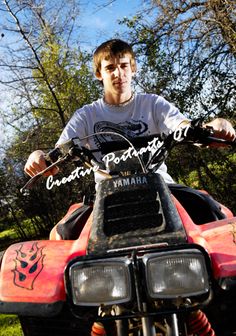 a young man riding on the back of an atv