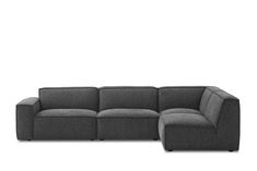 a gray sectional couch sitting on top of a white floor