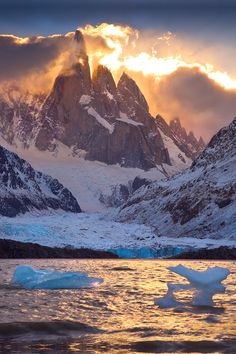 some icebergs floating in the water at sunset