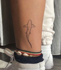 a small shark tattoo on the ankle