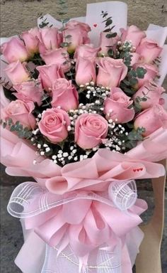 a bunch of pink roses in a bouquet