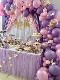 a purple and pink dessert table with lots of balloons