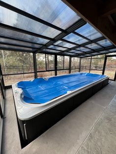 an outdoor hot tub in the middle of a room with glass walls and doors on both sides