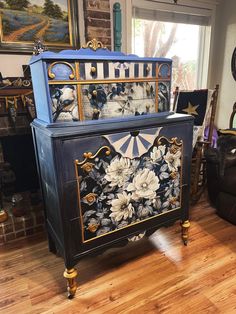 an ornate painted cabinet in a living room