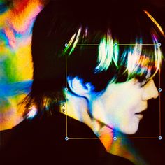 a woman with short hair is looking to the side in front of a colorful background