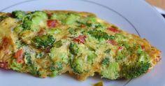 an omelet with broccoli and tomatoes on a plate