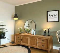 a living room with a rug, table and mirror on the wall in front of it