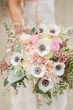 a bride holding a bouquet of pink and white flowers