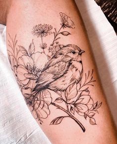 a bird sitting on top of a branch with flowers