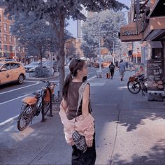 a woman is walking down the street with her purse