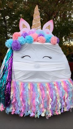 an inflatable unicorn with multicolored streamers and a horn on it's head