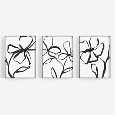 three black and white paintings hanging on the wall