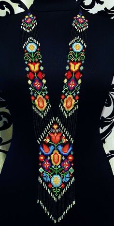 a woman wearing a black top with colorful beads on it