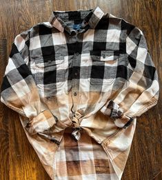 a shirt that is sitting on top of a wooden floor and has a tie around the collar