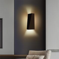 a wall light that is on the side of a wall next to a couch in a living room