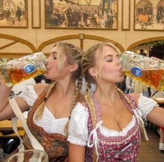 two beautiful women drinking beer from mugs