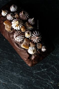 there is a chocolate cake with white and brown icing on the top, surrounded by sea shells