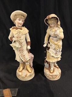 two porcelain figurines of girls with hats and dresses