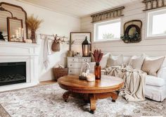 a living room filled with furniture and a fire place in front of a white fireplace