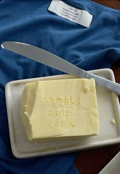 a piece of butter sitting on top of a cutting board with a knife next to it