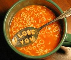 a spoon with the words love you spelled out in it and some type of soup