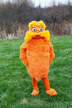 a person in an orange costume standing on grass