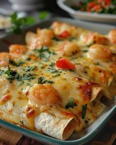 a casserole dish with shrimp, cheese and tomatoes on it is ready to be eaten