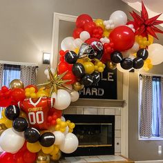 the balloon arch is decorated with black, white and gold balloons that spell out football