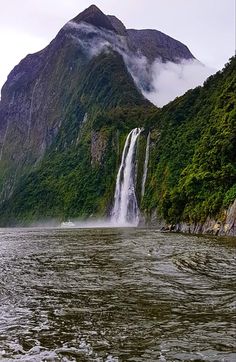 a large waterfall in the middle of a body of water