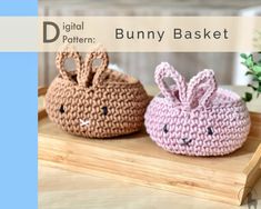 two crocheted bunny baskets sitting on top of a wooden table next to each other