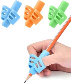 a hand holding a pencil with four different colored plastic clips attached to the top of it