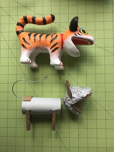 some paper mache animals are on a green table with scissors and other things to make them look like they're ready for action