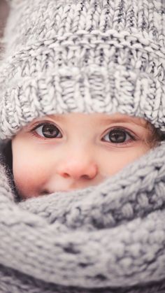 a baby wearing a knitted hat and scarf