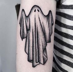 a black and white photo of a ghost tattoo on the arm