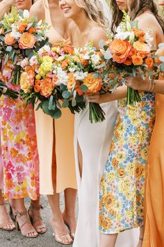 a group of women standing next to each other holding bouquets