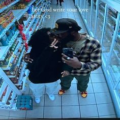 a man and woman standing in front of a grocery store aisle looking at their cell phones