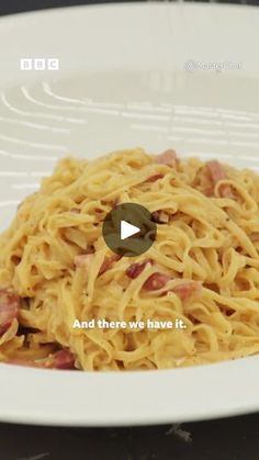 a white plate topped with pasta and ham