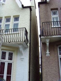 two buildings with balconies on the top and bottom floors, one has a balcony