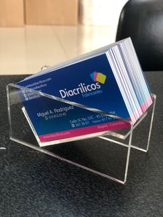 a stack of business cards sitting on top of a table next to a black chair