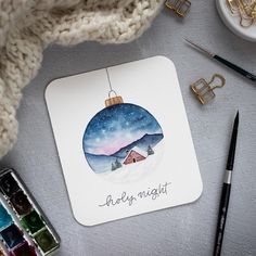 a christmas ornament with the words baby's night on it next to paint supplies