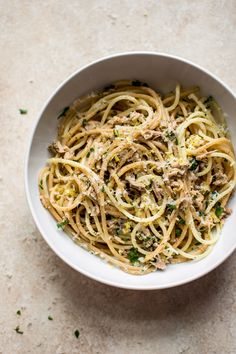 a white bowl filled with pasta and meat