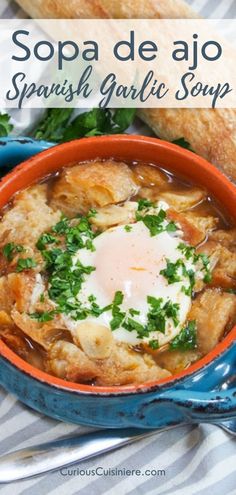 a bowl of soup with an egg on top and bread in the background, text reads sopa de ajo spanish garlic soup