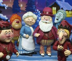 a group of figurines standing next to each other in front of a christmas scene