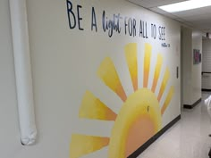 a hallway with a painted mural on the wall that says be a light for all to see