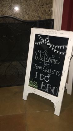 a chalkboard sign sitting on top of a tiled floor next to a fire place