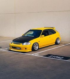 a yellow car parked in a parking lot