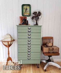 a green cabinet sitting next to a chair on top of a hard wood floor in front of a white wall