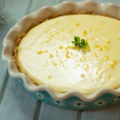 there is a pie in the dish on the table and it has a small green leaf sticking out of it