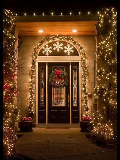 the front door is decorated with christmas lights and garlands for an elegant touch to any home