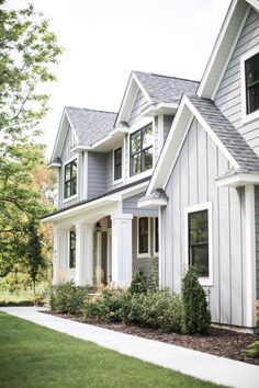 a gray house with white trim on the front and side windows is featured in an instagram